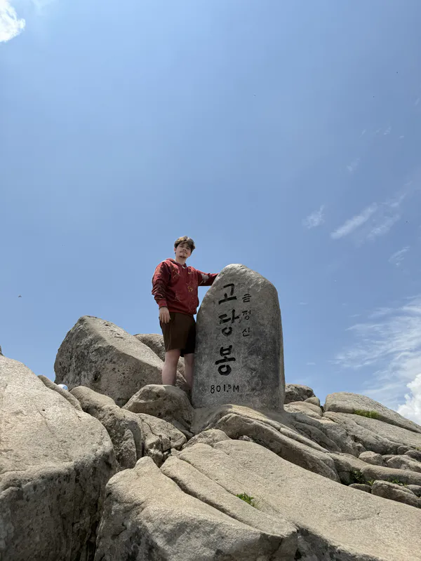 George beside a summit stone in Busan, South Korea